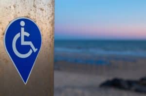 Symbol for people with disability adapted devices. Sunset backgroun at beach